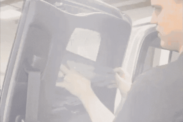 A technician smooths window tint film onto a vehicle's rear window, demonstrating the installation process and benefits of UV protection, heat rejection, and glare reduction—ideal for explaining What Window Tinting Really Is.