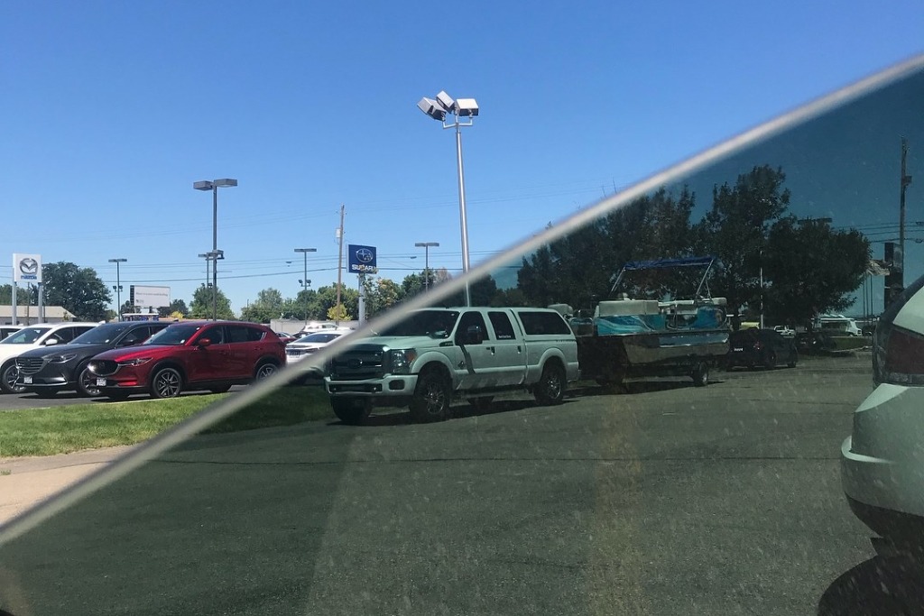 View through a partially tinted car window showing a stark contrast between tinted and untinted glass, clearly illustrating heat and glare reduction benefits relevant to Idaho drivers considering What Window Tinting Really Is.